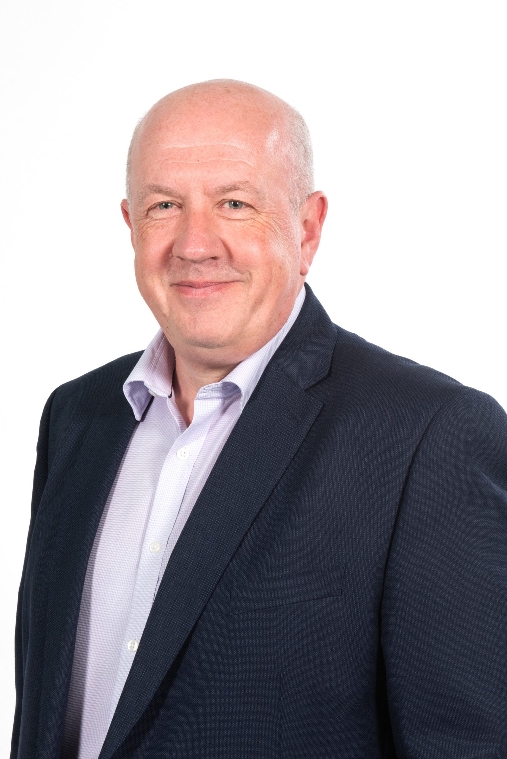 Steve Cox smiles and wears a suit
